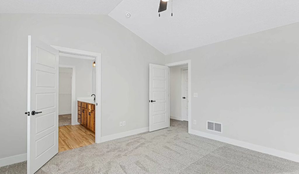 the living room and dining room of an empty house with white doors