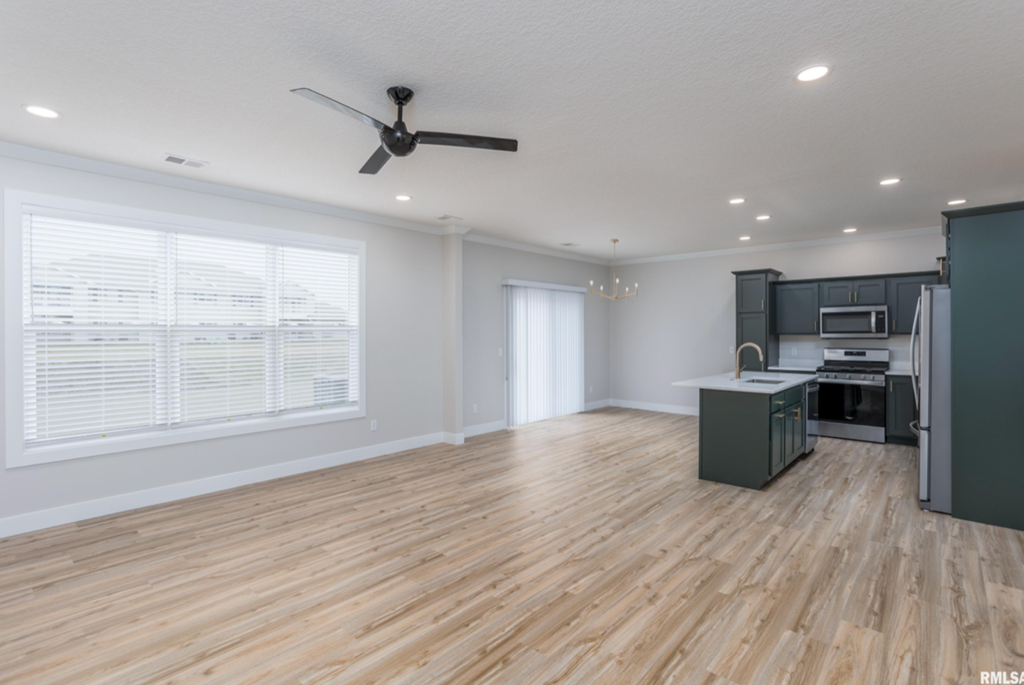 the living room and kitchen in a new home with wood flooring