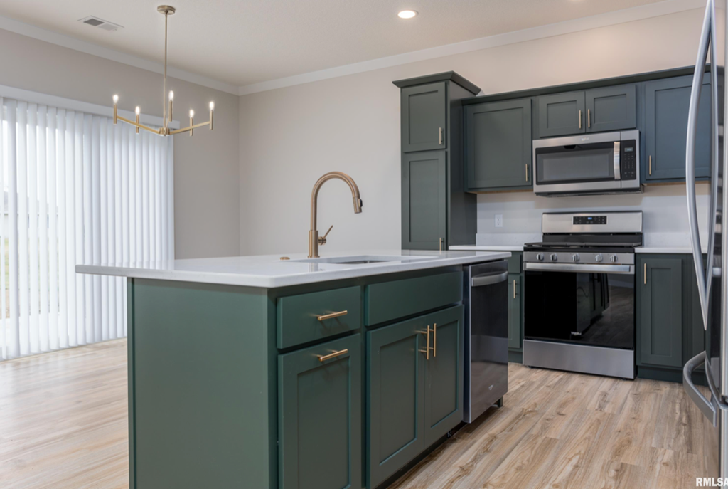 a kitchen with green cabinets and a white counter top