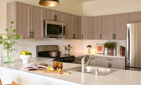 A modern kitchen with a white countertop and a black stove.