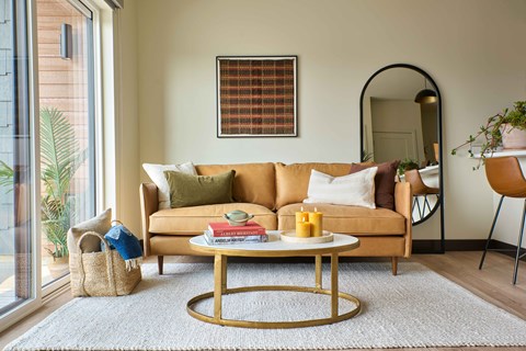 A living room with a sofa, a coffee table, and a mirror.