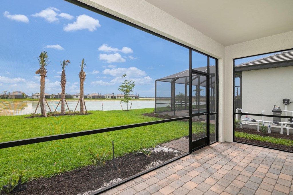 a patio with a view of a grassy field and a glass door