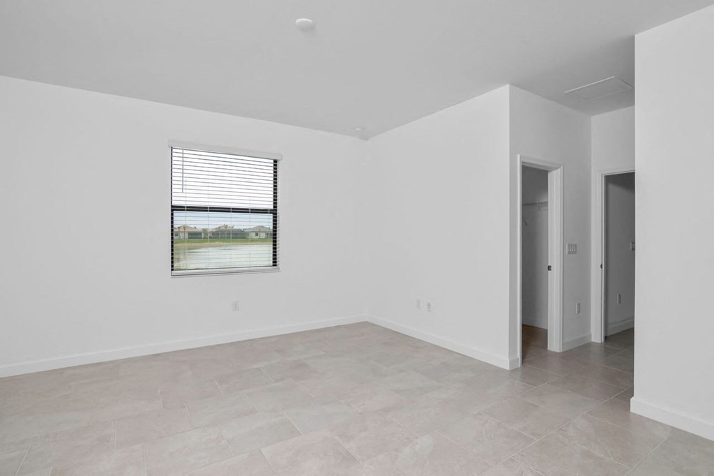 an empty living room with white walls and a window