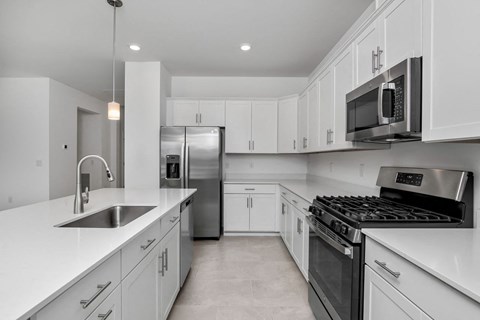 a kitchen with white cabinets and stainless steel appliances