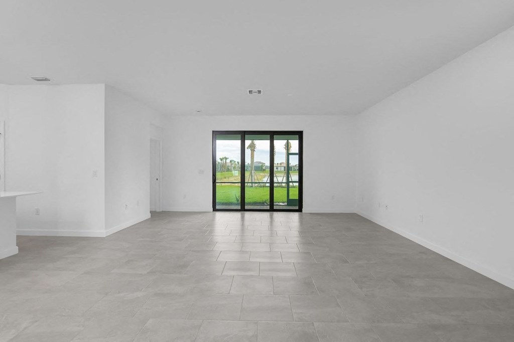 an empty living room with white walls and a sliding glass door