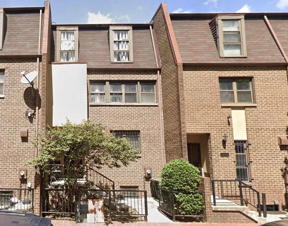 a brick apartment building with stairs and a sidewalk
