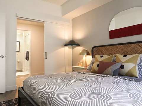 A bedroom with a large bed and a lamp.