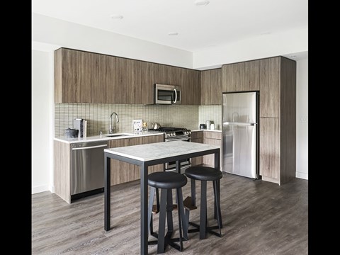 A kitchen with a table and two stools.