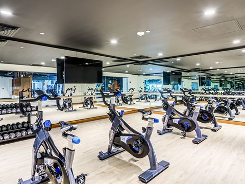 A gym with stationary bikes and a mirror.