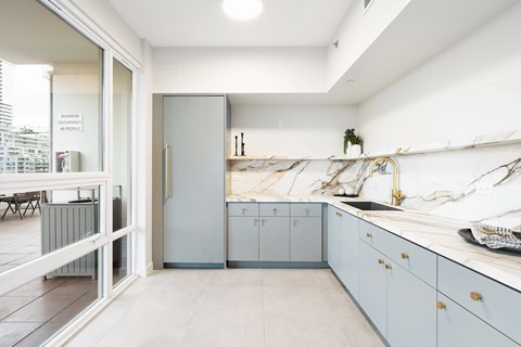 A kitchen with a refrigerator, cabinets, and a countertop.