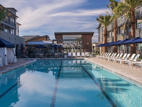 A large swimming pool with a building in the background.
