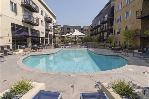 A swimming pool in a courtyard surrounded by buildings.