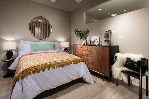 A bedroom with a large bed and a wooden dresser.