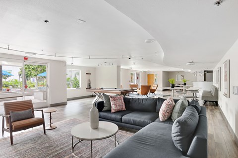A living room with a grey couch and a wooden chair.