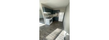 an empty kitchen with white appliances and blue cabinets
