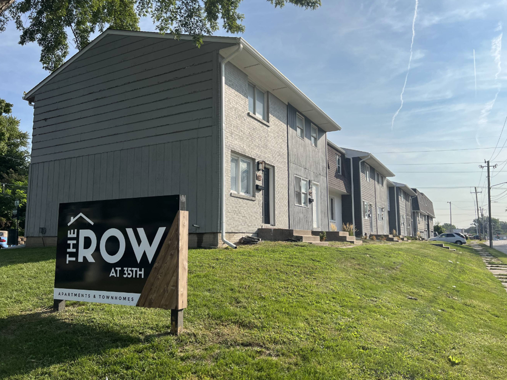 a row of houses with a sign in the grass