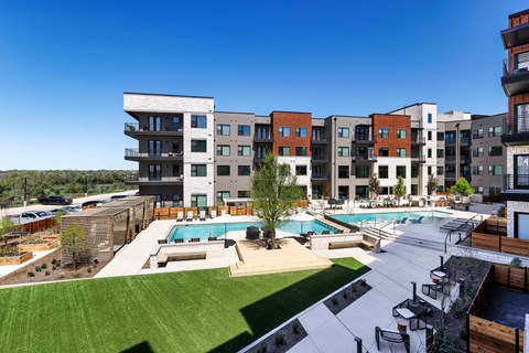 A large apartment complex with a pool in the middle.