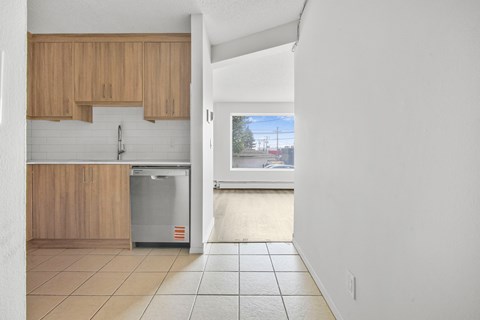 A kitchen with wooden cabinets and a fridge.