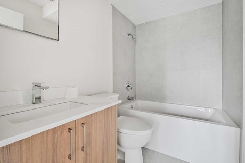 A white bathroom with a sink, toilet, and bathtub.