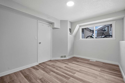 A room with a wooden floor and a window.