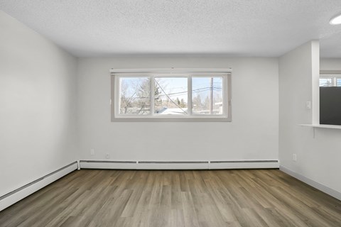 A room with a window and wooden flooring.