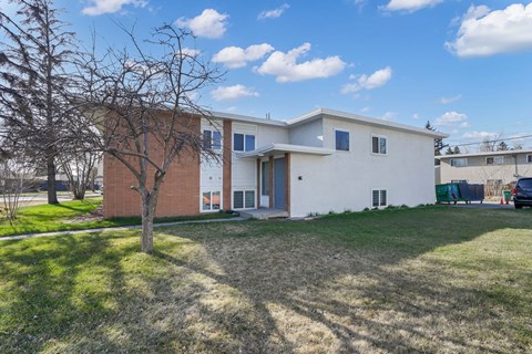 A modern two-story house with a white exterior and a red brick section on the lower floor.
