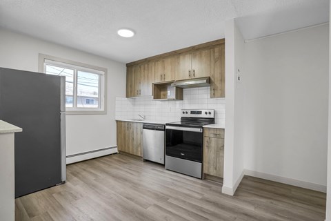 A kitchen with a stainless steel oven and wooden cabinets.