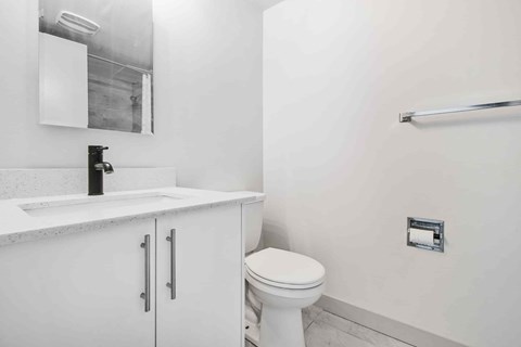 A white toilet sits next to a sink in a bathroom.