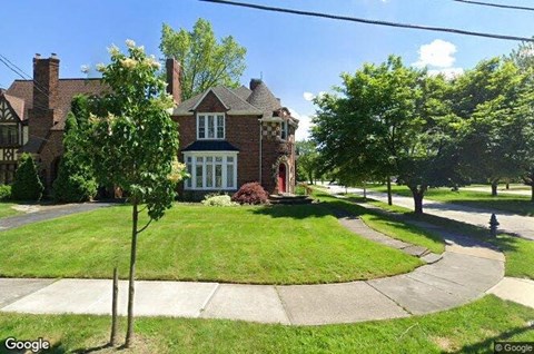 a house on the corner of a sidewalk