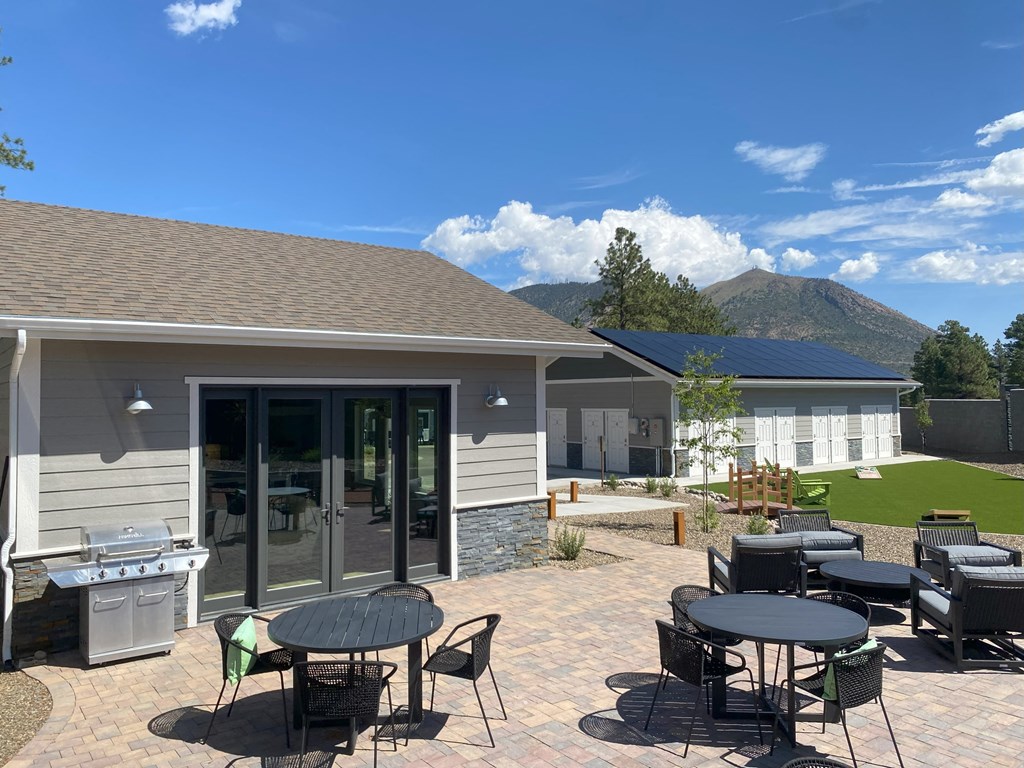 a patio with tables and chairs in front of a building