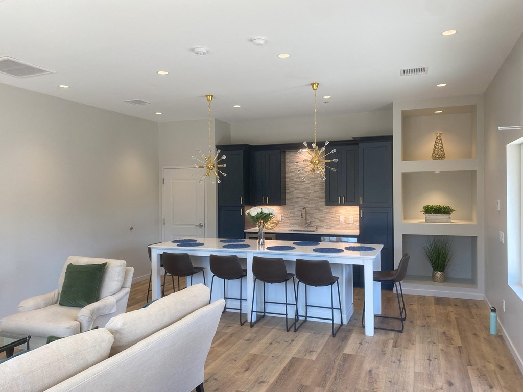 a dining area with a blue table and chairs and a kitchen with blue cabinets