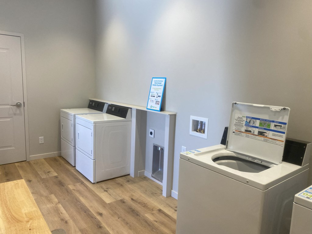 a laundry room with washer and dryer and a sink