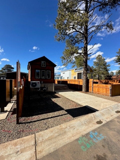 a small red house with a fence and a tree