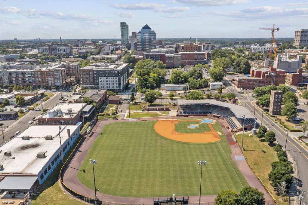 an aerial view of a baseball field with a city in the background