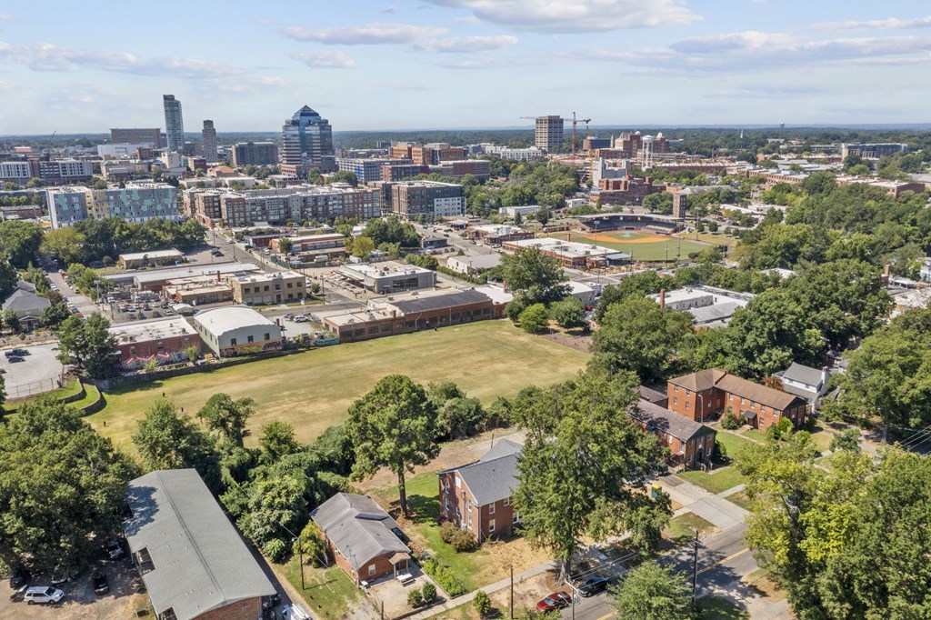 an aerial view of the city with a field in the foreground