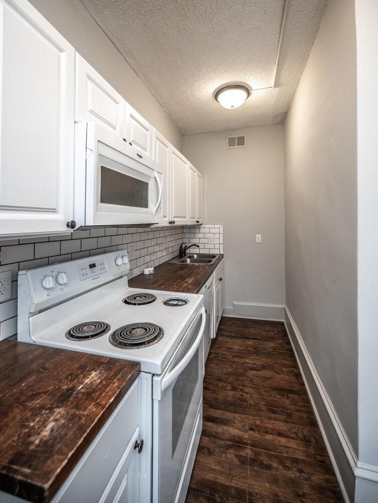 a kitchen with white appliances and white cabinets
