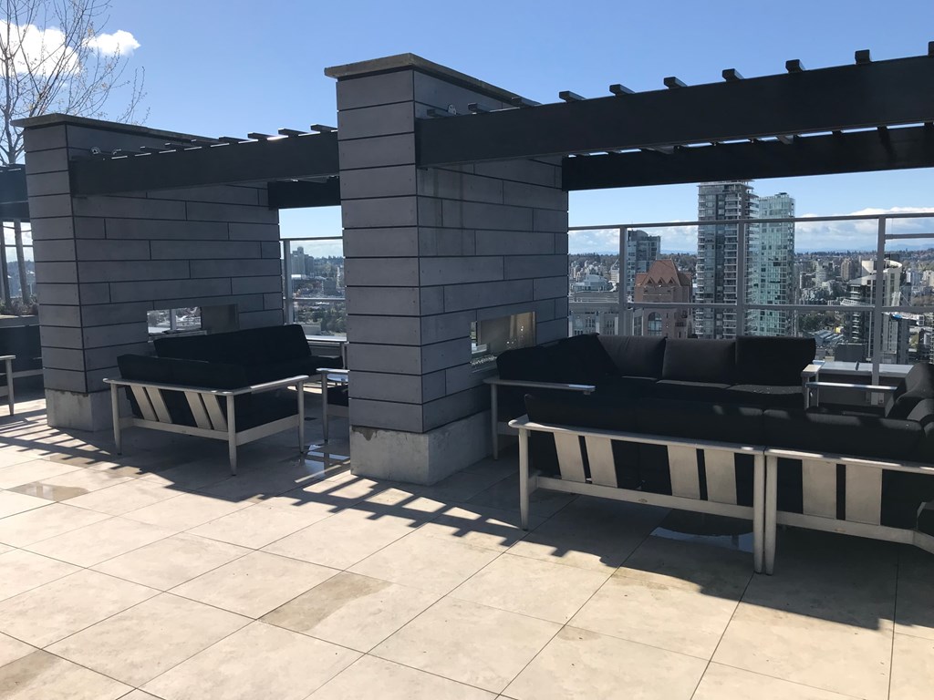 the top of a roof terrace with couches and a view of the city