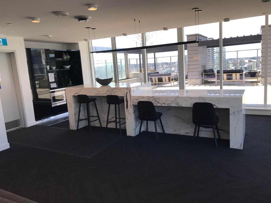 a kitchen with a marble counter top and black stools