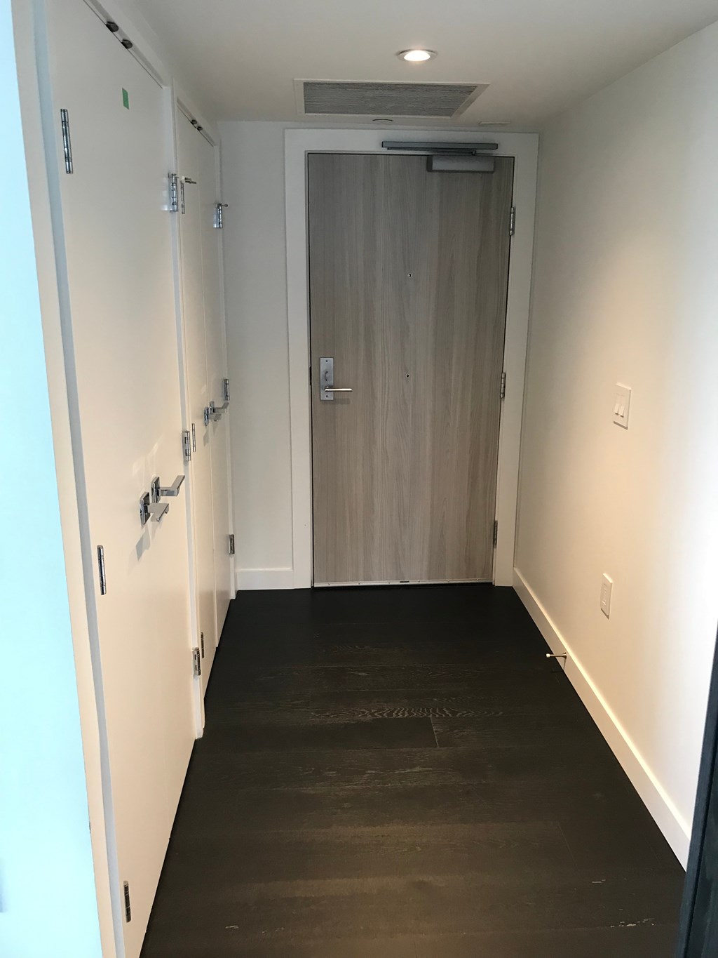 a large wooden door in a hallway with a wooden floor