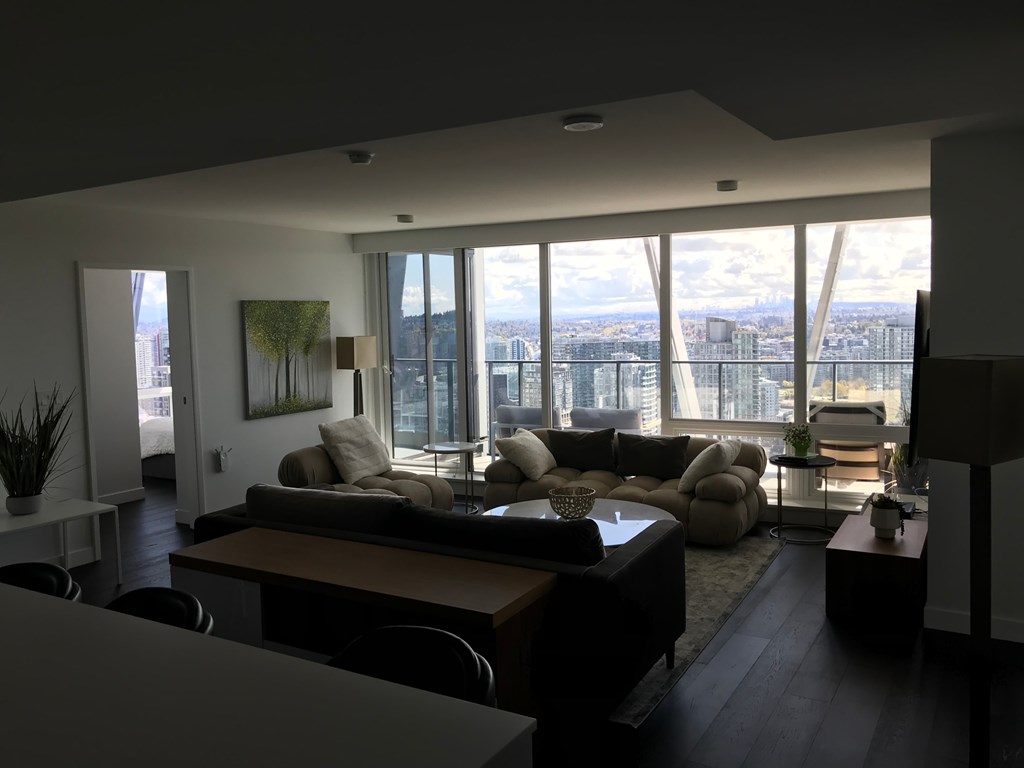 a living room with a view of the city and a couch and a table