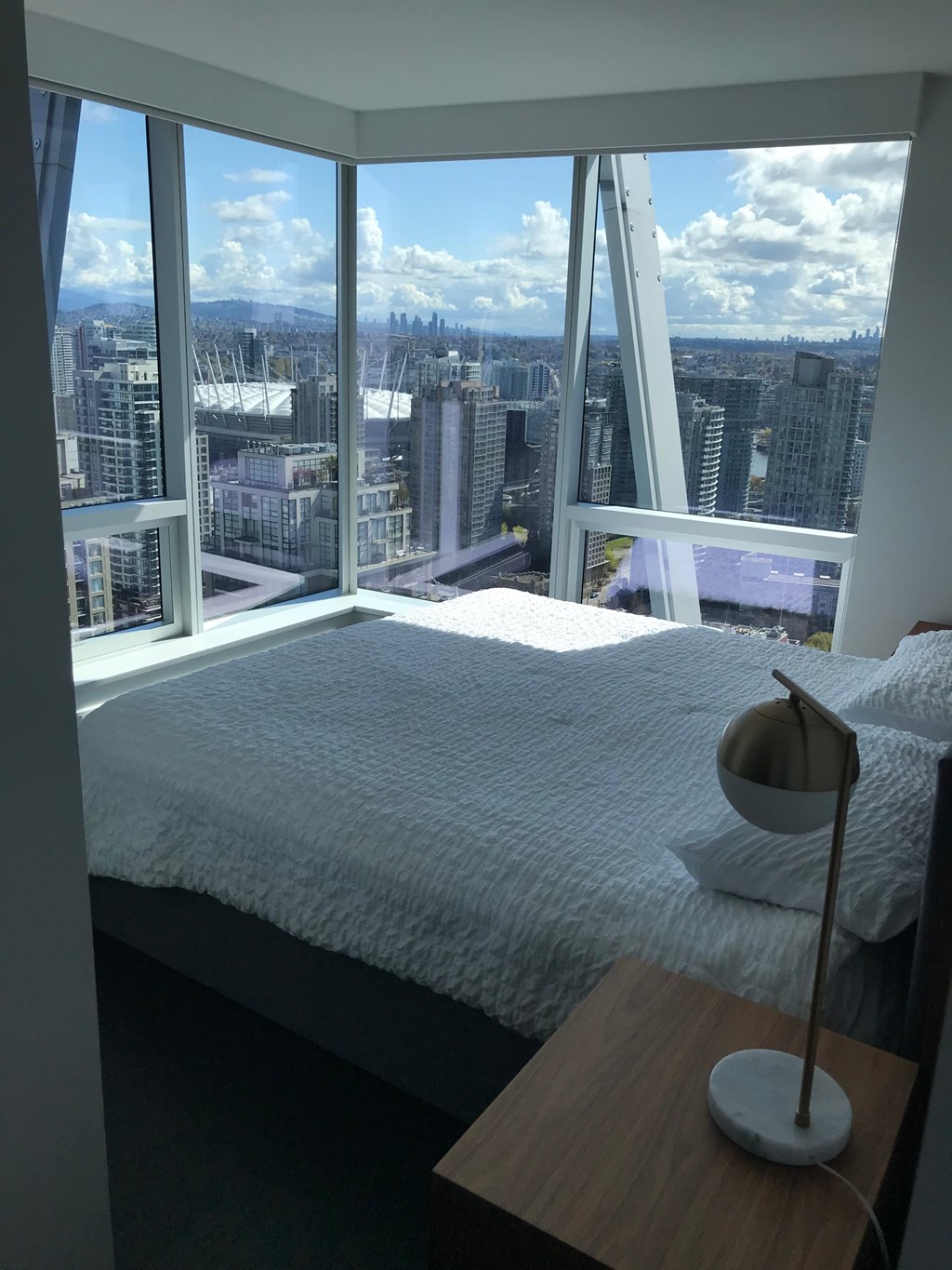 a bedroom with a large bed and a view of the city