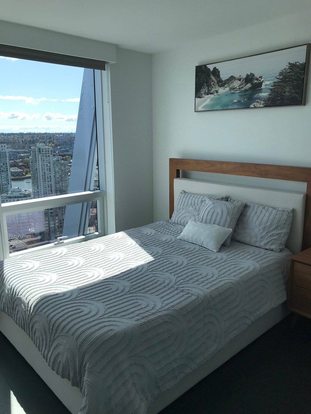 a bedroom with a bed and a large window
