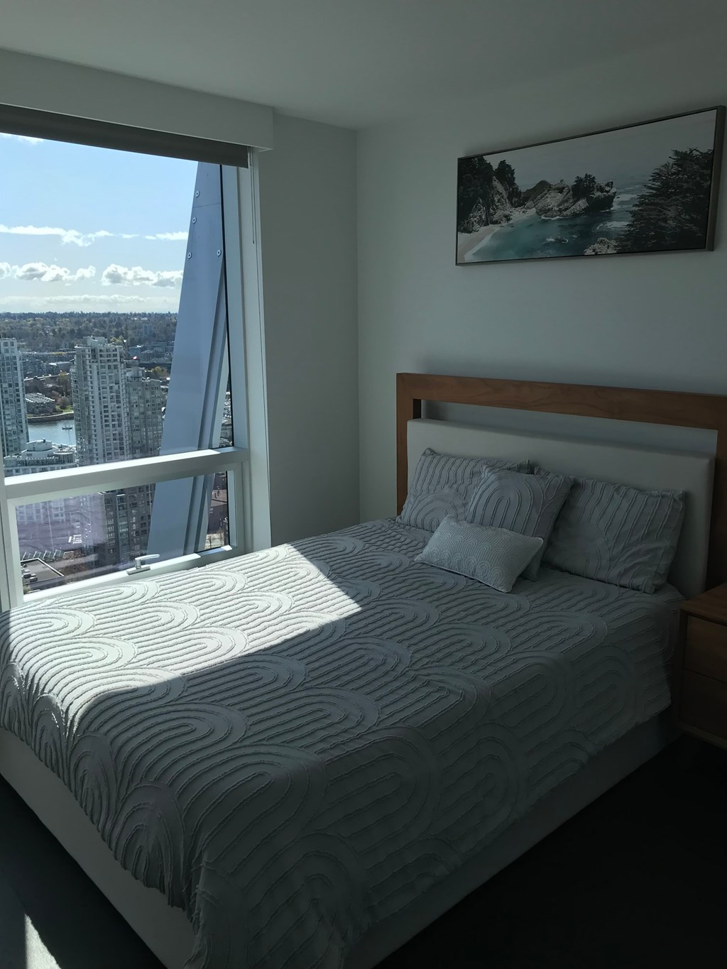 a bedroom with a bed and a window with a city view