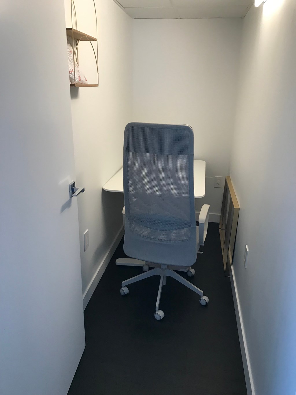 a chair in a small room with a desk