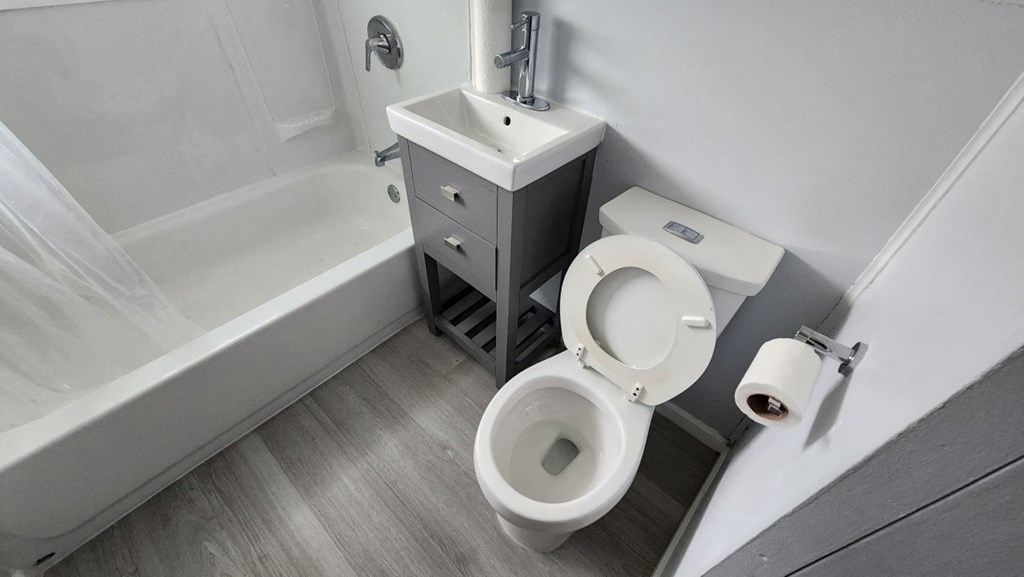 a bathroom with a toilet and a sink and a bath tub