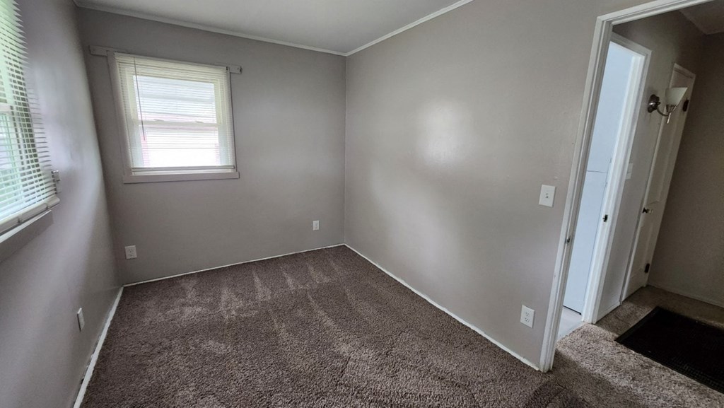 a empty room with carpet and a window