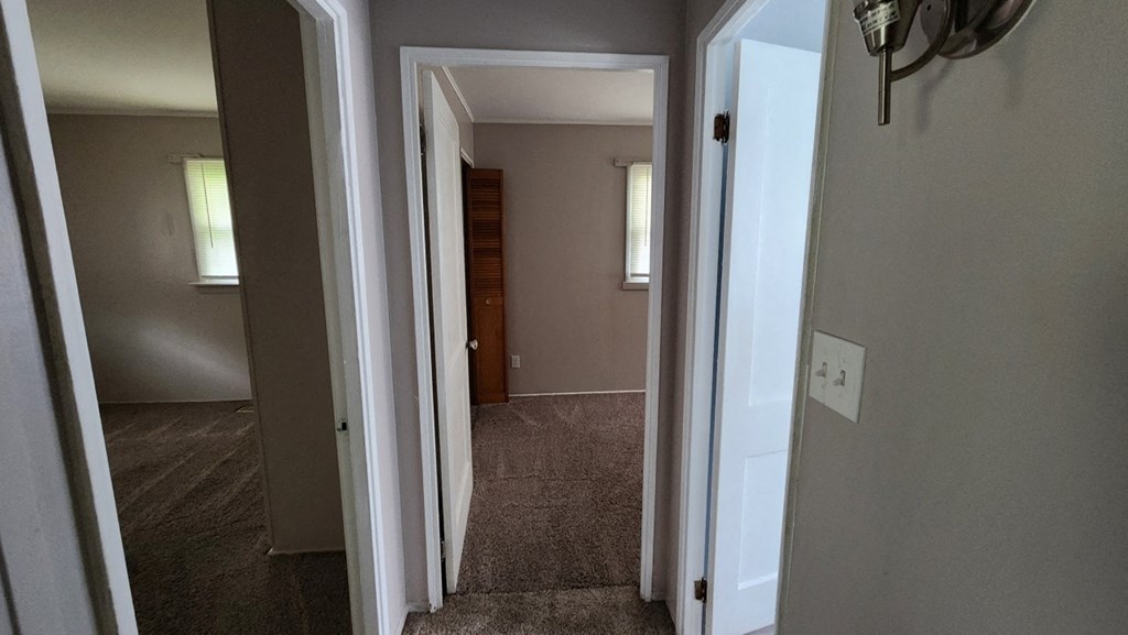 a view of a hallway with a door to a bedroom and a closet