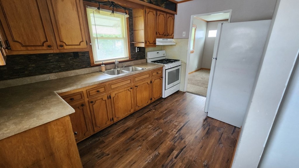 a kitchen with wooden cabinets and a sink and a refrigerator