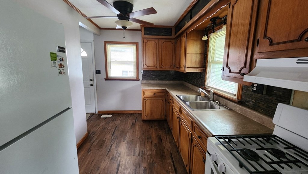 a kitchen with wooden cabinets and a stove and a sink
