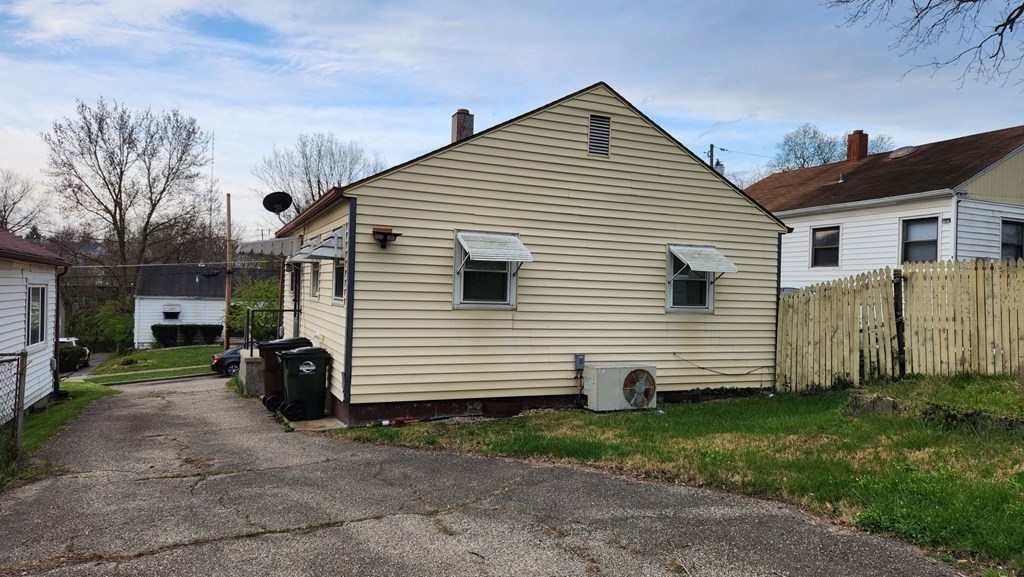 the back of a house with a yard and a fence